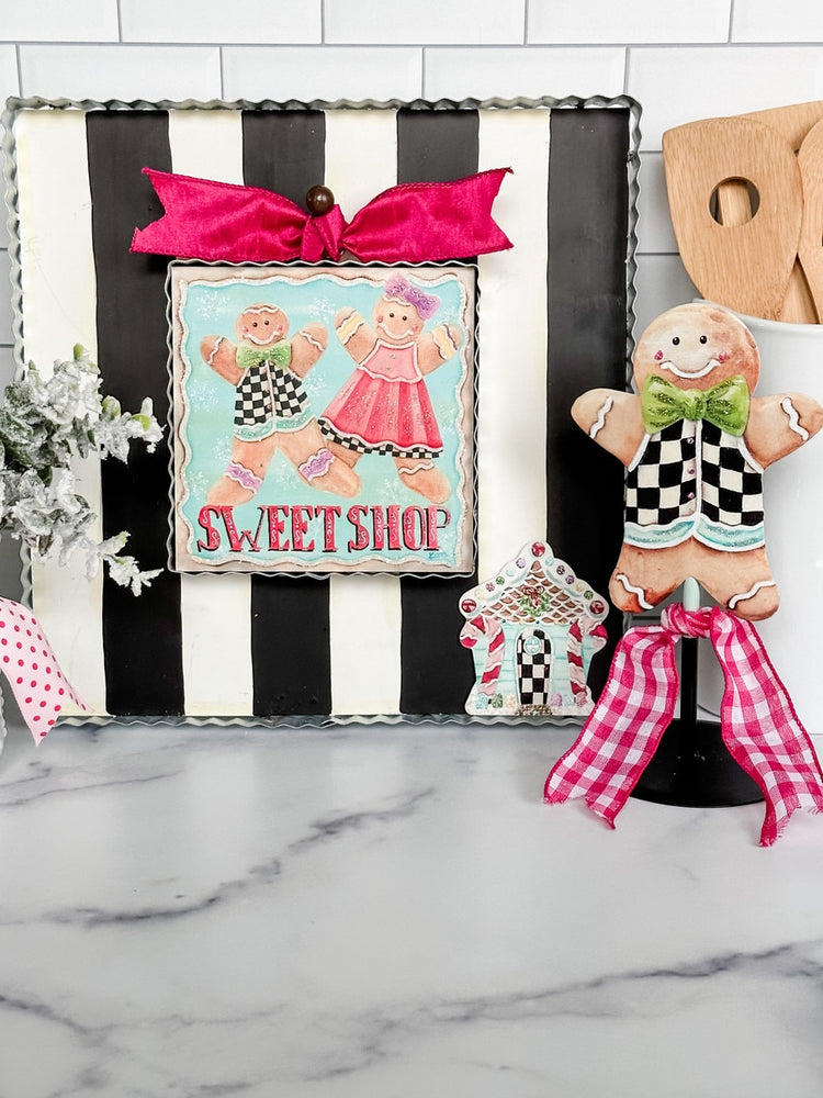 Black and white striped mini gallery display board with a scalloped edge and pink bow accent.