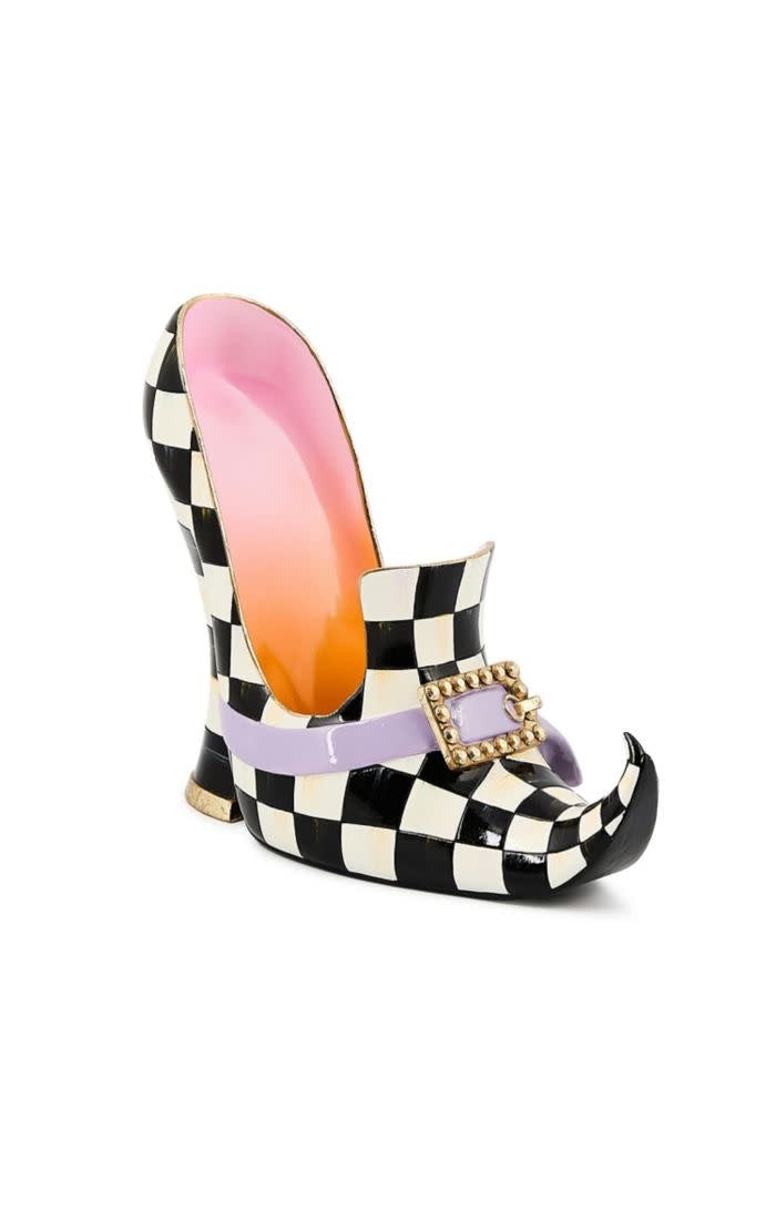 Resin figurine of a black witch's boot with orange accents standing on a base.