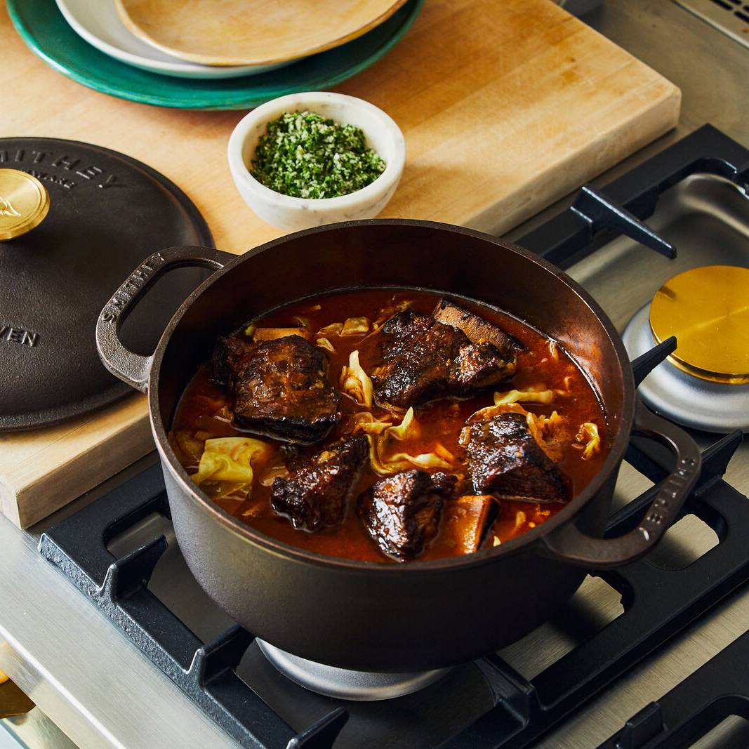 3.5 Qt Dutch Oven on a stovetop filled with braised short ribs and cabbage in a rich broth.