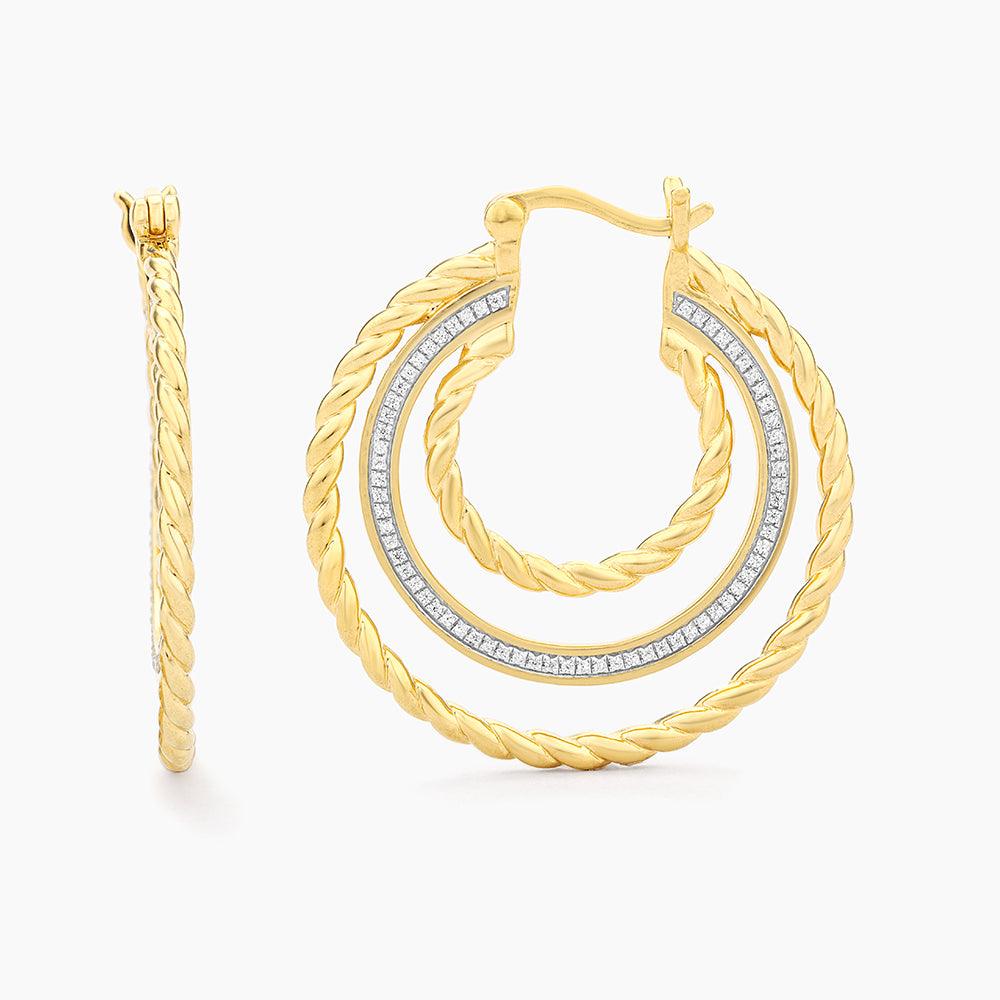 Gold triple hoop earrings with twisted rope texture and a diamond-studded middle band.