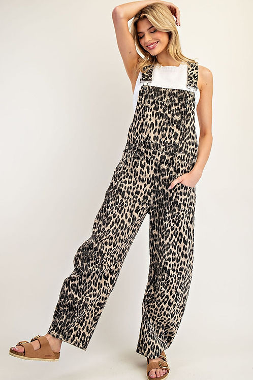 Woman wearing Denise leopard print wide leg overalls with a white top and tan sandals.