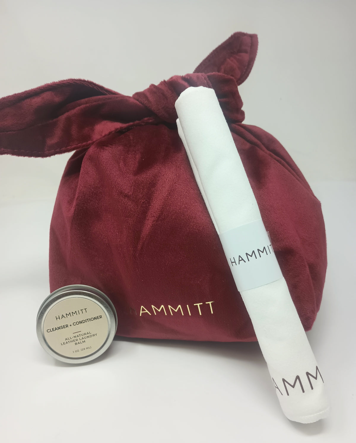 Hammitt TLC Kit with burgundy velvet pouch, white cloth, and small tin of leather balm.