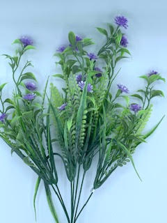 Artificial grass bush with small purple flowers and green leaves.