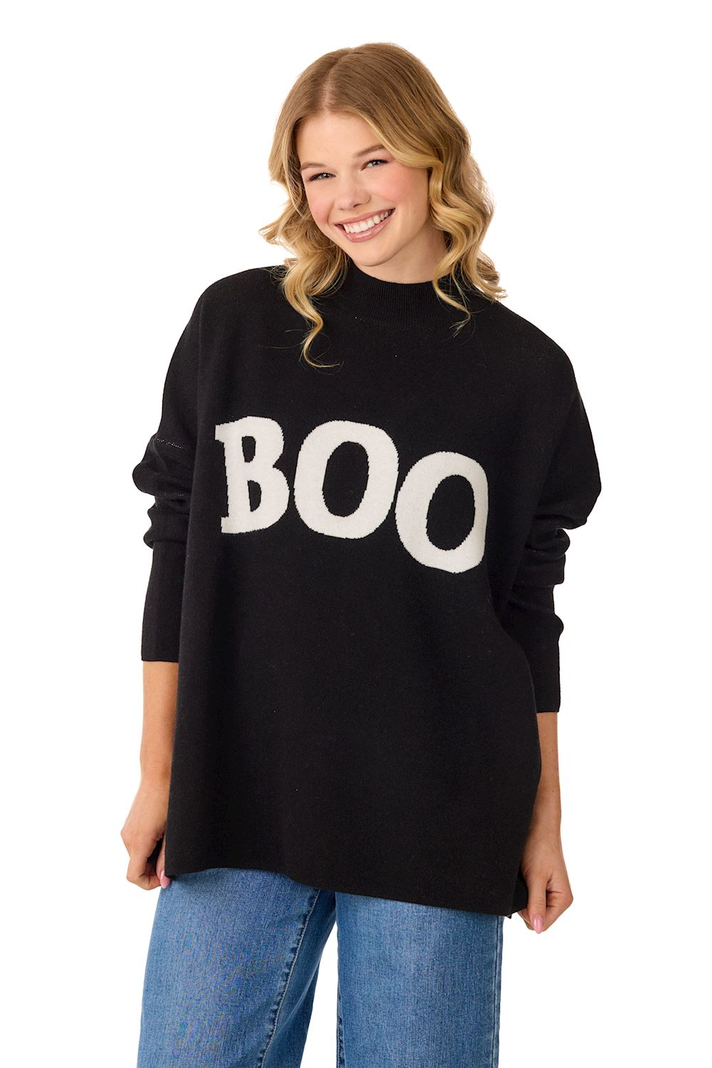 Woman wearing a black jacquard knit mock neck sweater with white BOO text and side slit hem.