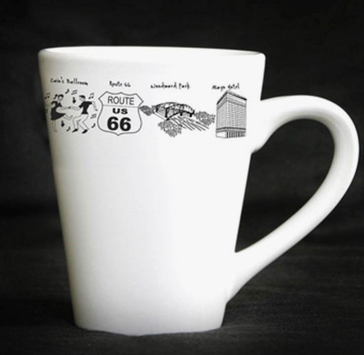 White tapered ceramic mug featuring black line art of Tulsa landmarks and Route 66.