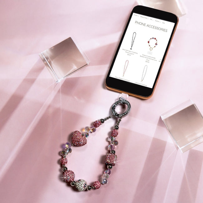 Pink crystal and iridescent beaded phone wrist strap with a silver gemmed clasp and heart charm.