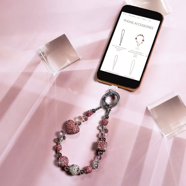 Pink Crystal Wristlet Beaded Hands-Free Silver Wrist Strap attached to a smartphone.