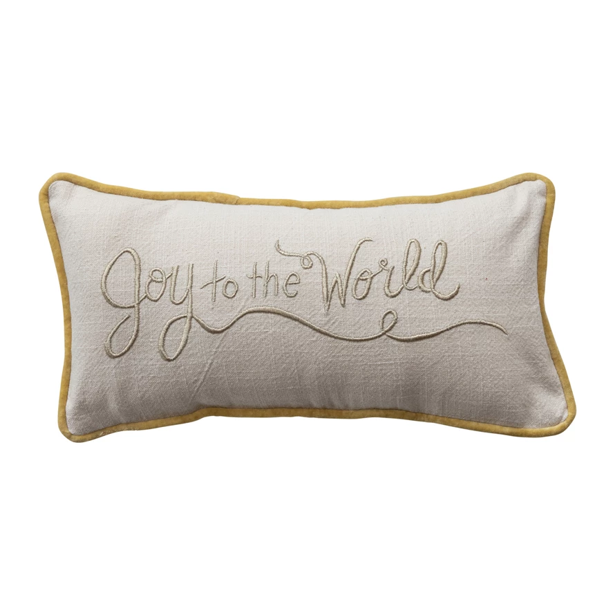 Cotton slub lumbar pillow in cream with gold velvet trim and embroidered "Joy to the World" script.