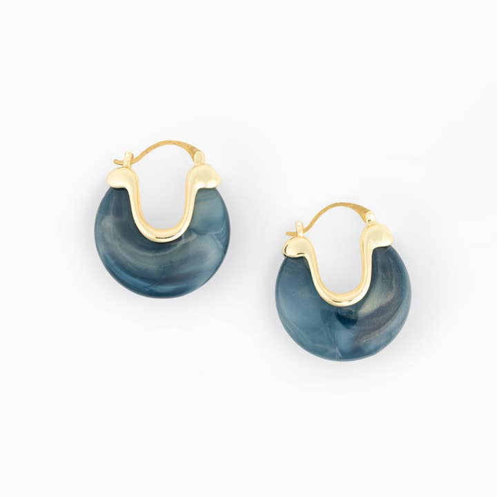 Mabel Earrings featuring blue marbled resin hoops with gold-plated brass metal accents.