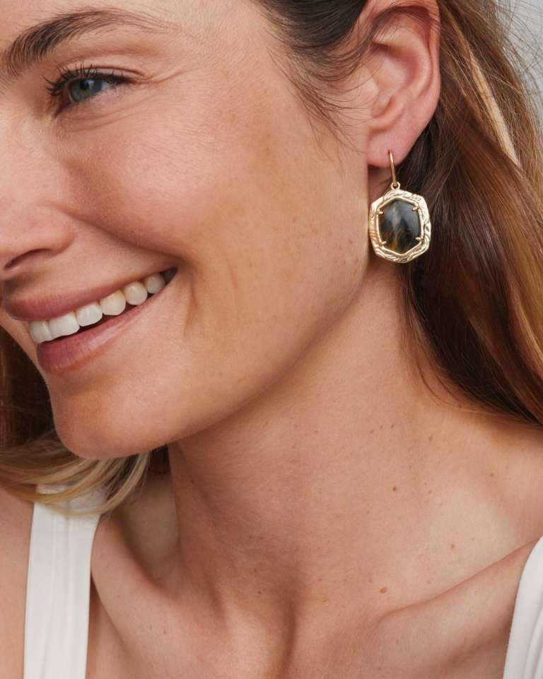 Woman wearing Tiger Striped Daphne Drop Gold Earrings with etched metal and dark stone.