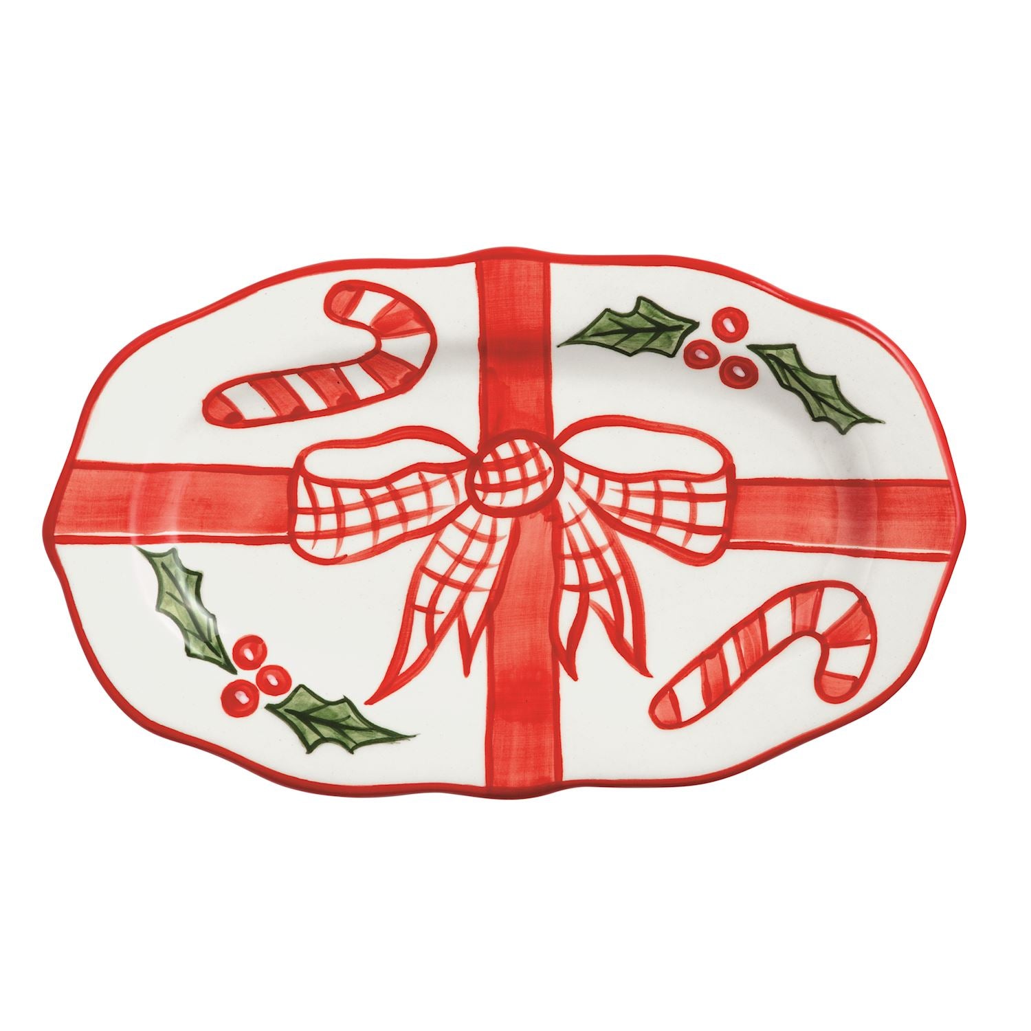 Oval ceramic plate with hand-painted red bow, candy canes, and holly leaves on a white background.
