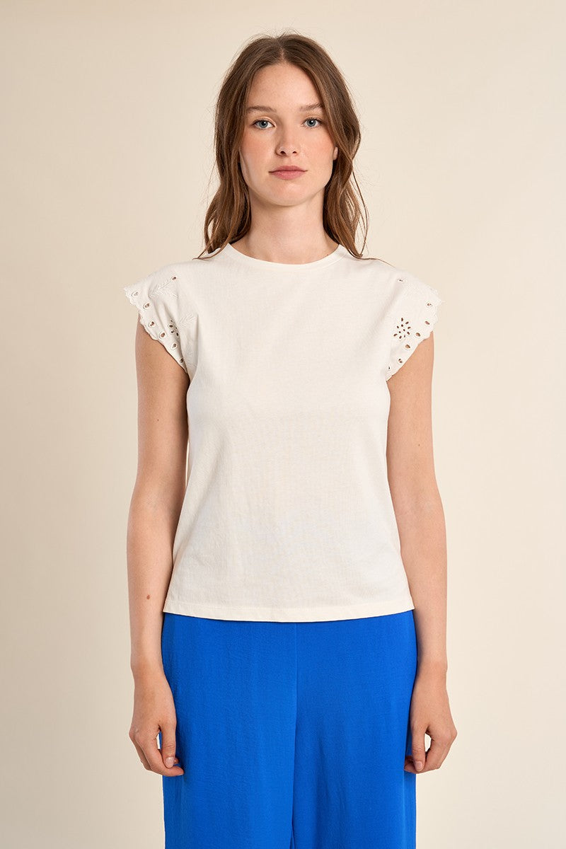 Woman wearing a white cotton Madison knitted tee with short embroidered eyelet sleeves.