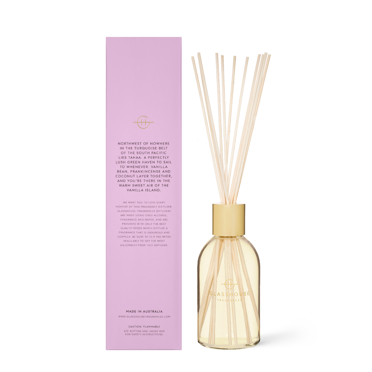 Glass reed diffuser bottle with amber liquid, caramel-colored wood reeds inside.