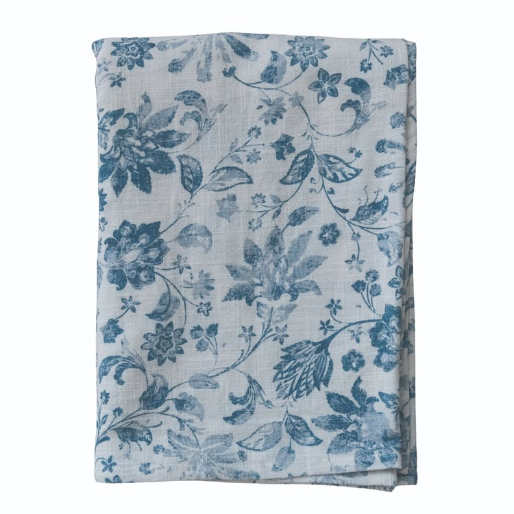 Folded white cotton slub tablecloth with a blue floral and botanical print.