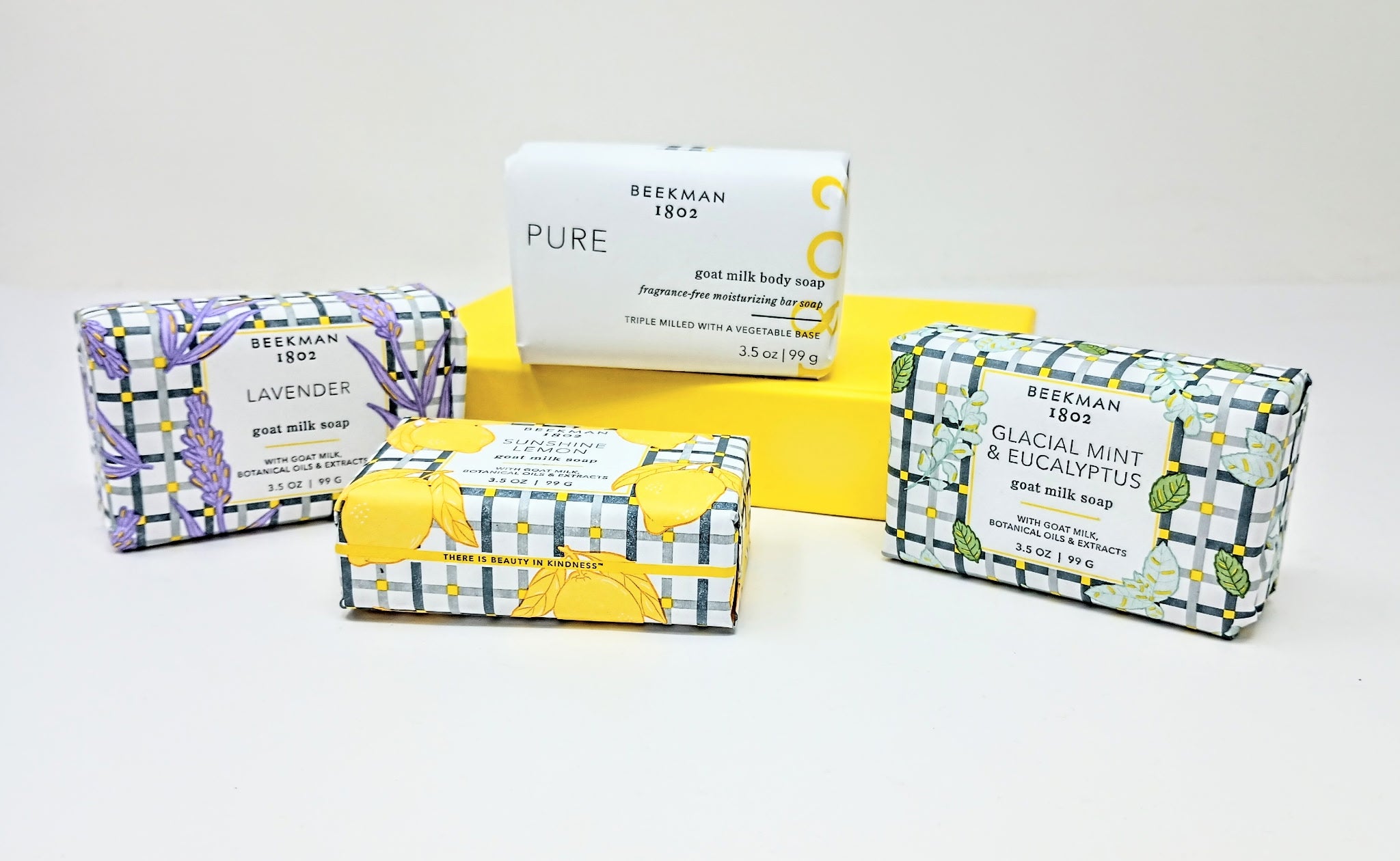 Set of four travel-sized goat milk bar soaps in lavender, lemon, mint, and eucalyptus scents.