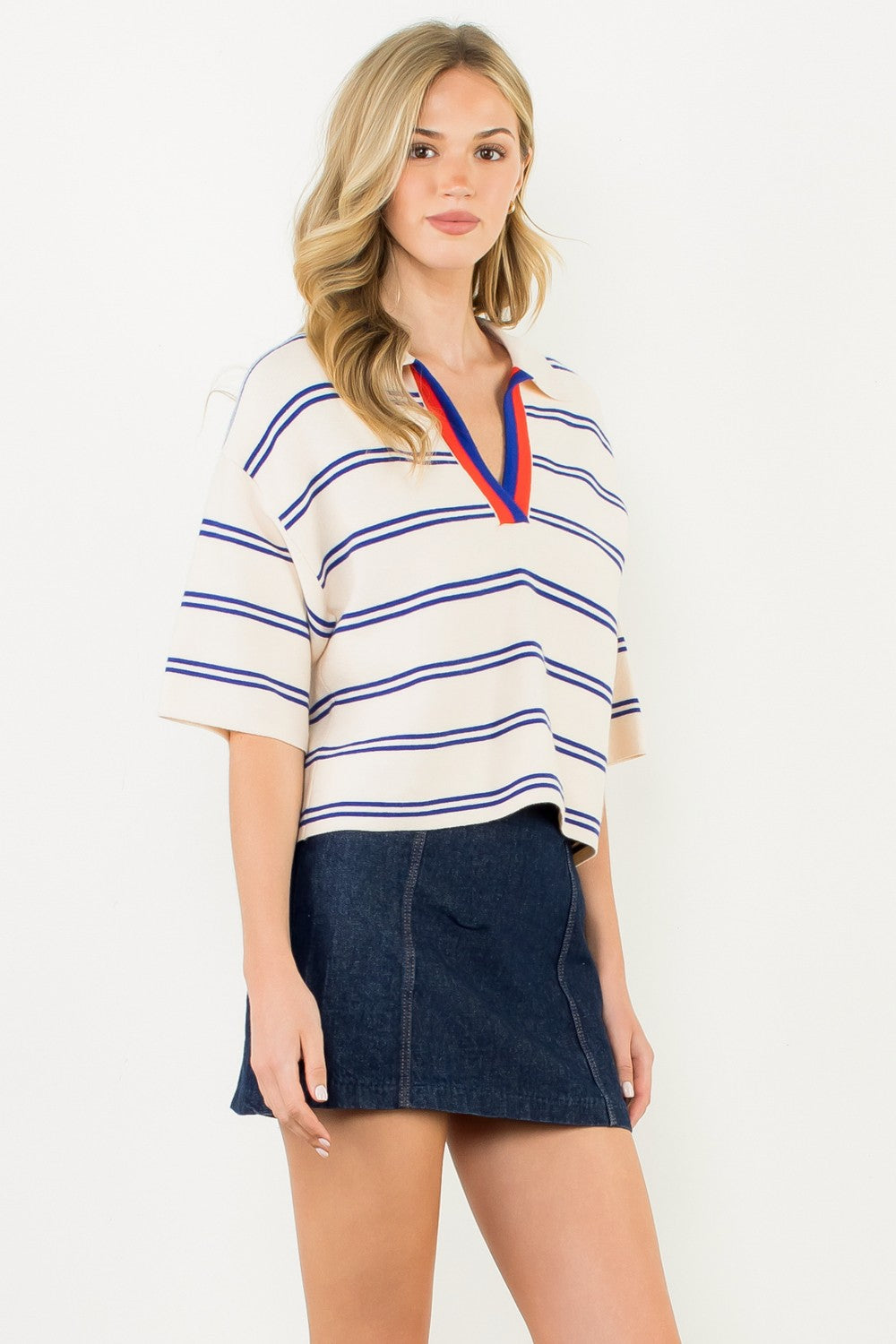 Woman wearing the Jasmine Short Sleeve Striped Knit Top in cream with blue stripes and red trim.