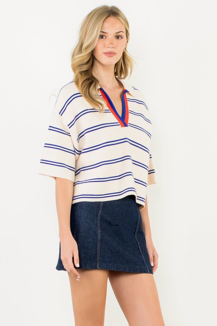 Woman wearing the Jasmine Short Sleeve Striped Knit Top in cream with blue stripes and red trim.