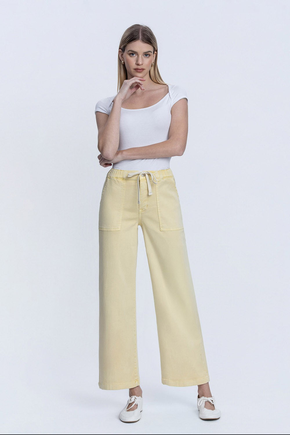 Woman wearing yellow Stella high rise baggy wide leg jeans with elastic drawstring waistband.