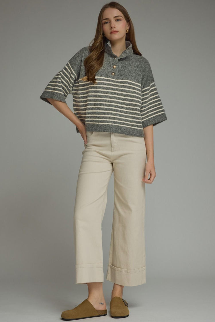 Woman wearing a grey and white Charlene Stripe Short Sleeve Knit Top with a mock neck and buttons.