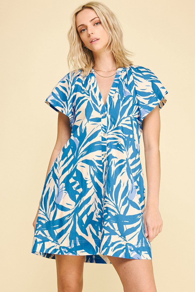 Leah botanical print cotton mini dress with V-neck, cap sleeves, side pockets, and button front.
