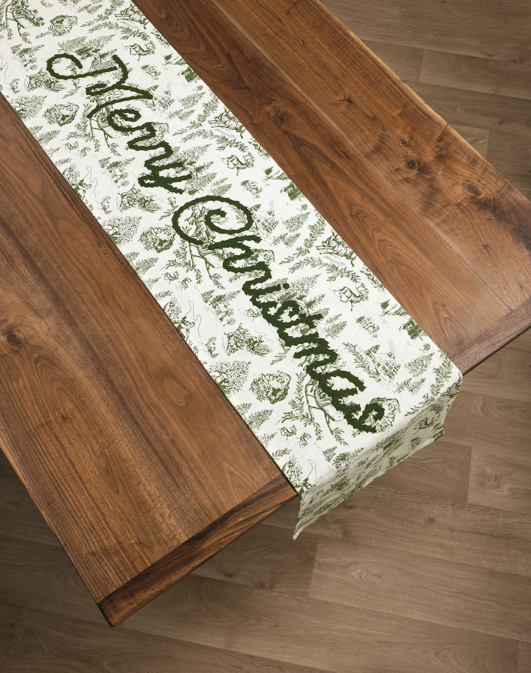Green Toile Table Runner with 'Merry Christmas' script on a wooden dining table.