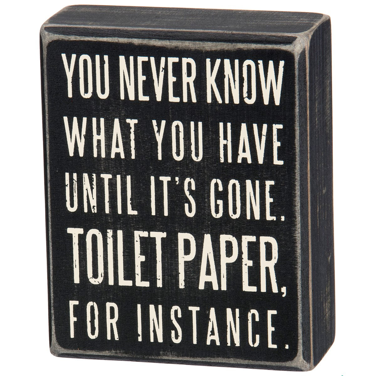 Black wooden box sign with white text reading 'You never know what you have until it's gone. Toilet paper, for instance.'