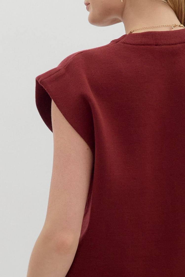 Close-up back view of a woman wearing a burgundy Olivia crewneck sweater knit muscle tee top.