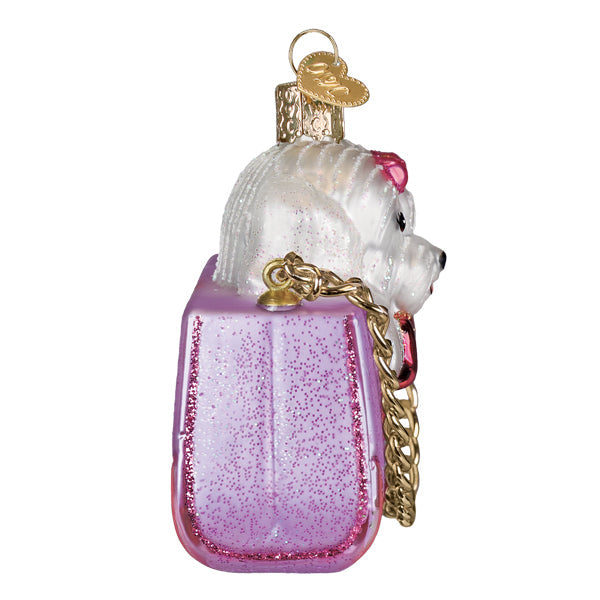 Posh Pup In Purse ornament: a small plush dog figurine peeking from an open designer handbag with holiday sparkle.