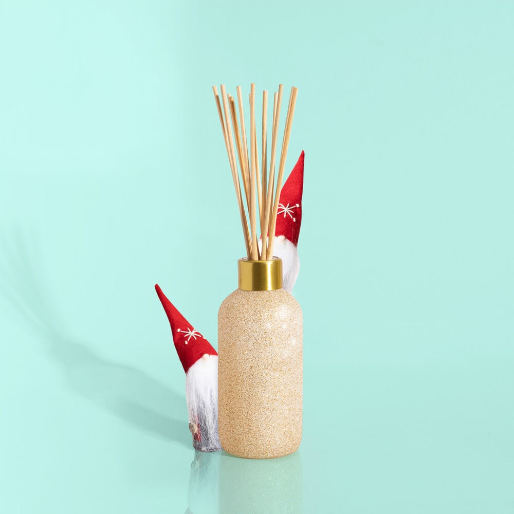 Glam Reed Diffuser in Pumpkin Dulce color with a cylindrical glass bottle holding scented oil and reed sticks.
