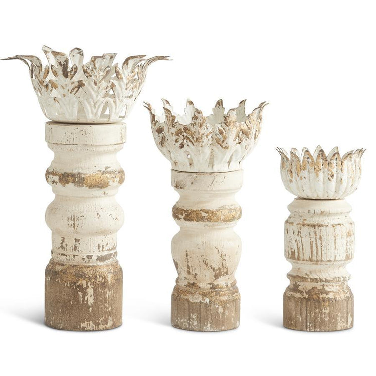Set of three distressed whitewashed and gold wood candleholders with ornate metal leaf tops.