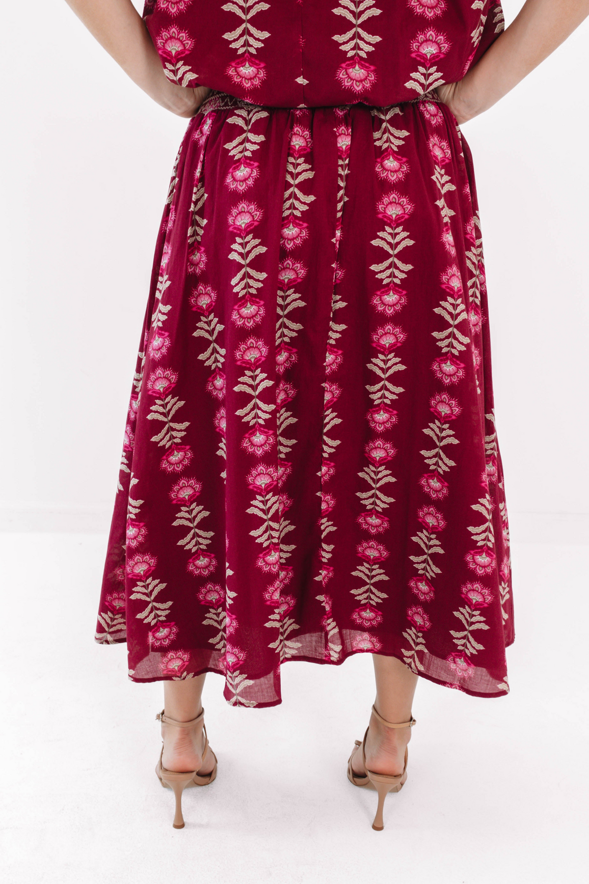Back view of the Arianne Midi Skirt in wine with a floral pattern and elastic waistband.