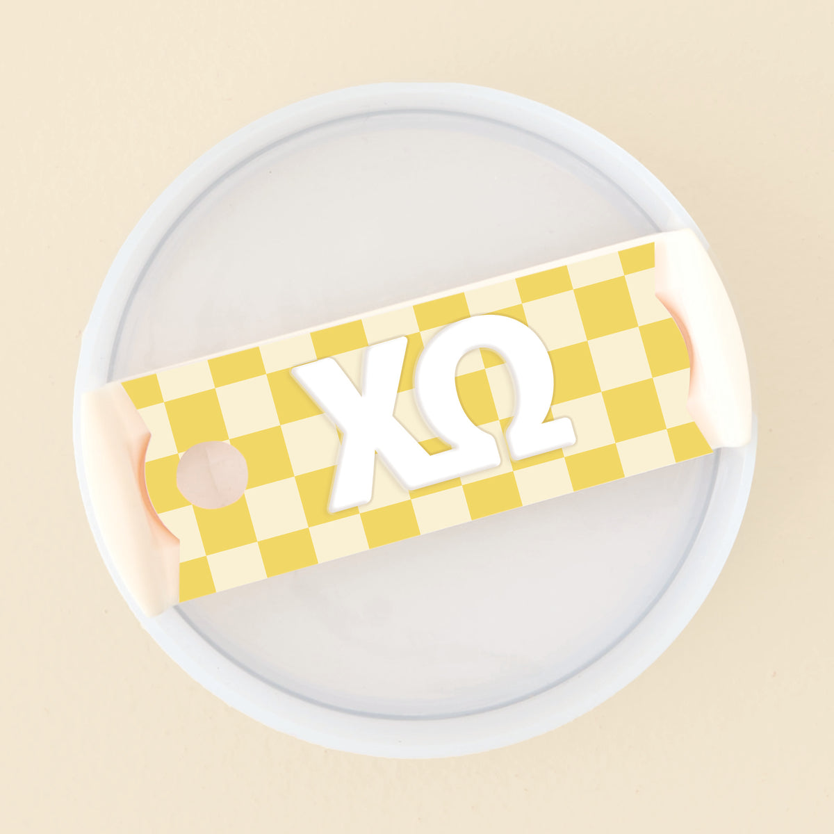 Yellow checkered acrylic tumbler lid tag with white Chi Omega Greek letters.