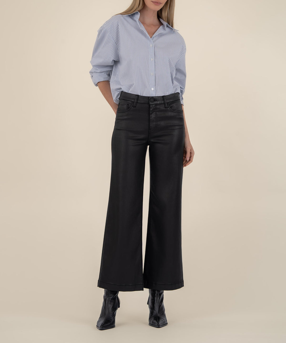 Woman wearing Katelyn Meg high rise wide leg black coated pants with a blue striped shirt.