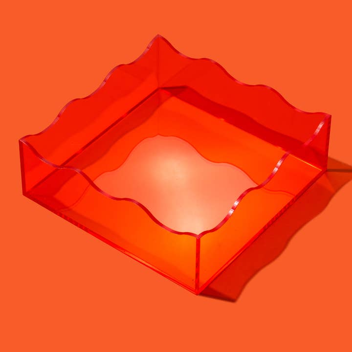 Square acrylic serving tray with wavy edge detail in clear material.