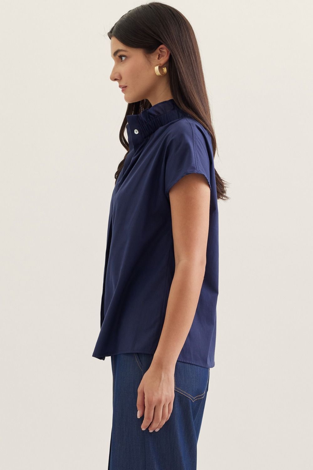 Aliana solid cap sleeve top in light beige with ruffled stand collar.