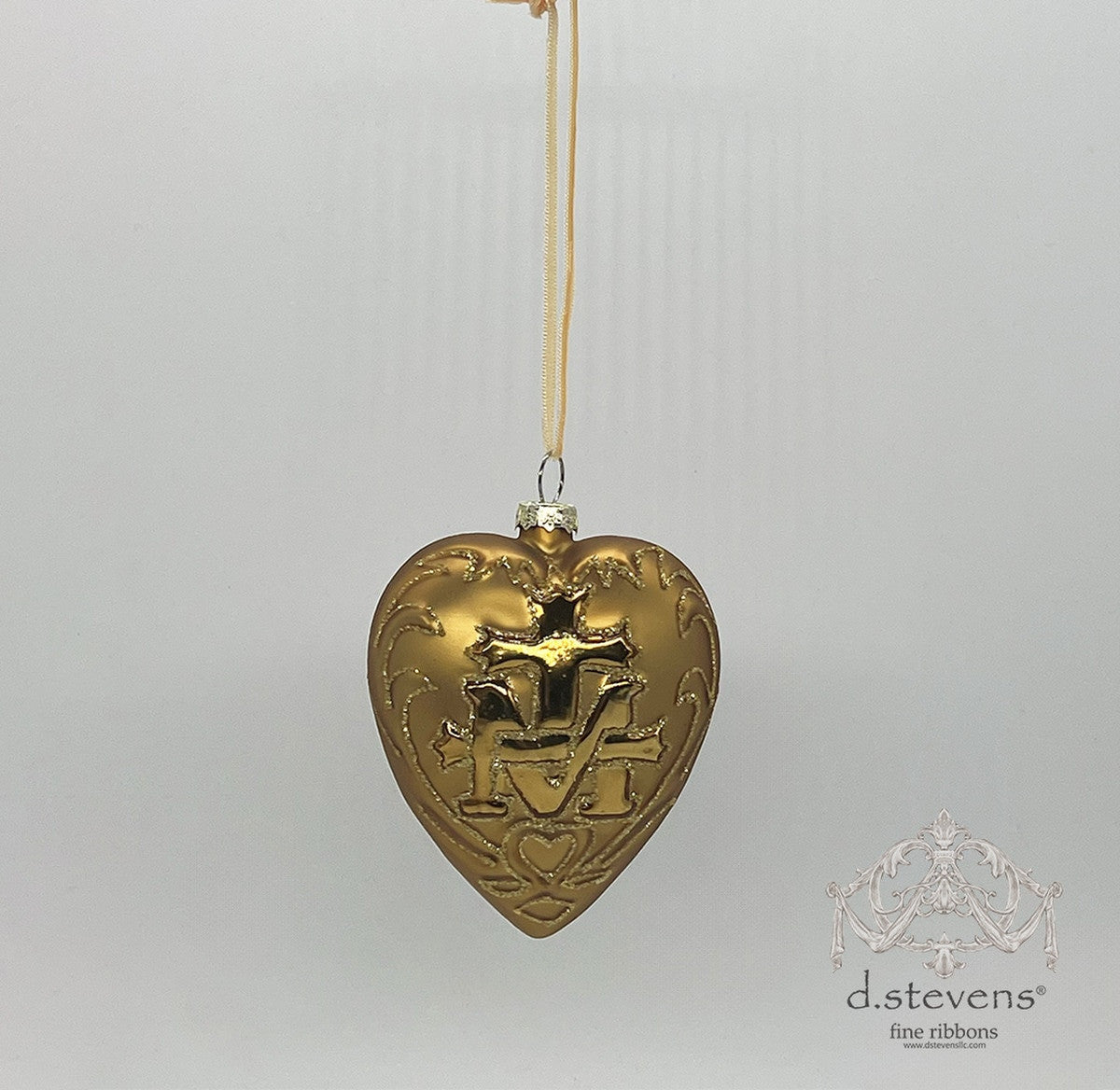 4-inch gold glass heart-shaped ornament with an embossed crest design hanging from a ribbon.