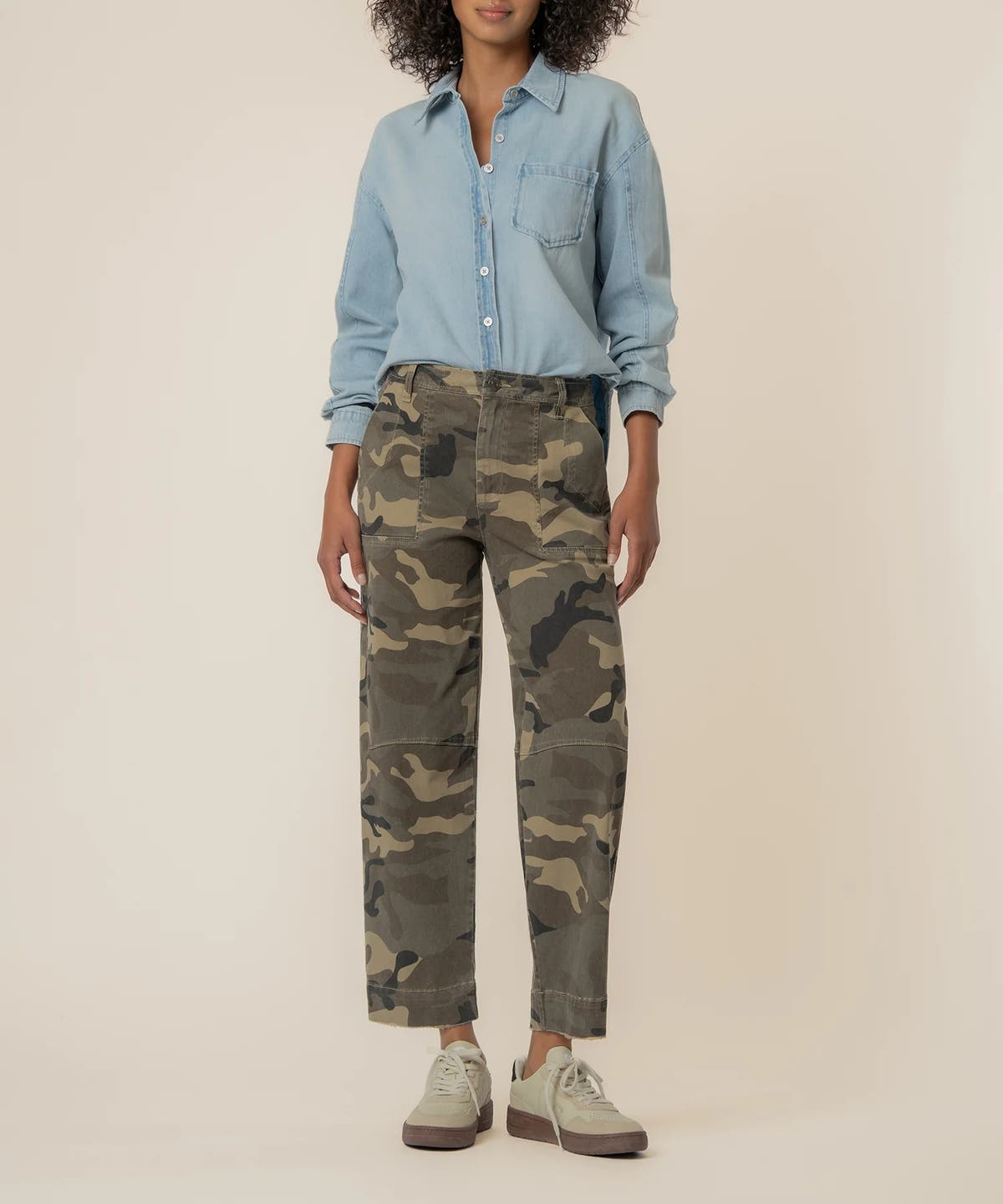 Woman wearing Ashton wide leg barrel pants in a camo pattern with a light blue denim shirt.