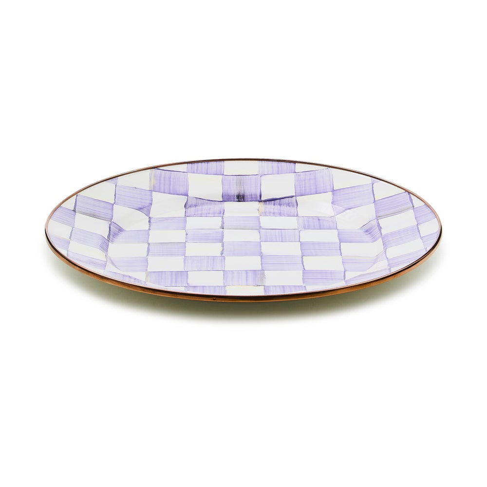 Hand-glazed steel charger plate with violet checkered enamel rimmed in bronzed stainless steel.