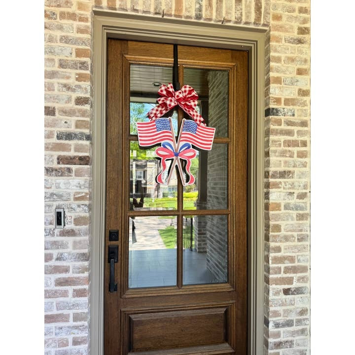 Sweet Land of Liberty Flags Door Hanger with two American flags and a red and white checkered bow.