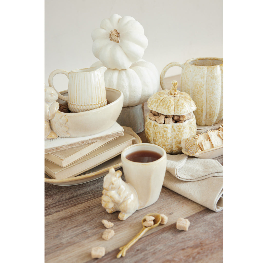 Cream reactive glaze stoneware mug with a small squirrel figure attached to the side.
