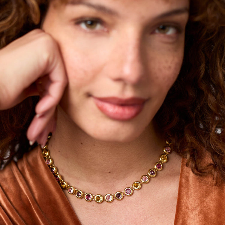 Model wearing a Rainbow Tennis Necklace with 24K gold plating and multi-colored glass stones.