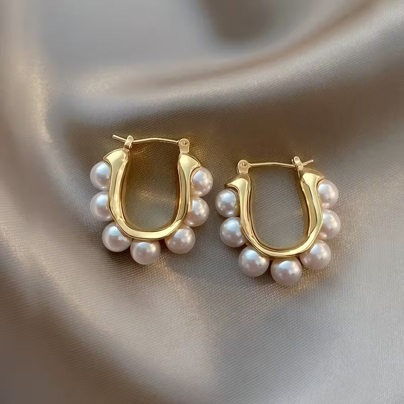Faux pearl inlaid earrings with a delicate stud silhouette featuring subtle patterned detailing.