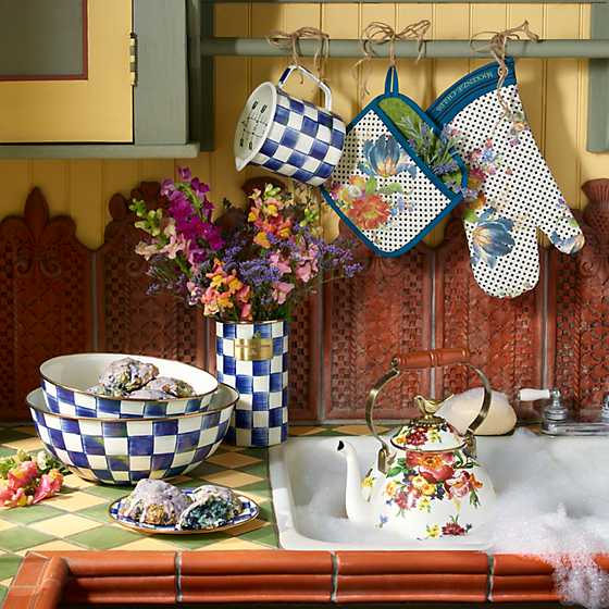 Two Royal Check Everyday Bowls stacked on a tiled counter next to a floral kettle and blue flowers.