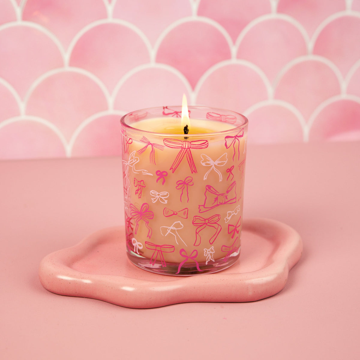 Pink Sweet Grace candle in a reusable glass vessel with an elegant bow on the lid.