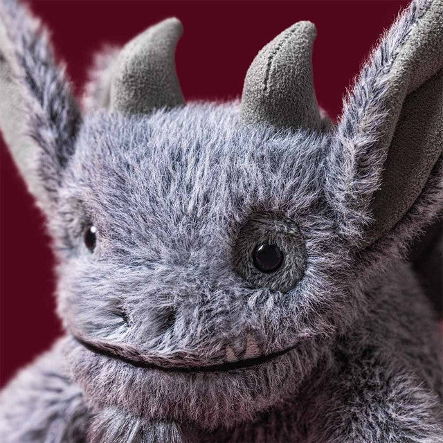Close-up of Growlston Gargoyle, a grey plush toy with horns, large ears, and a friendly smile.