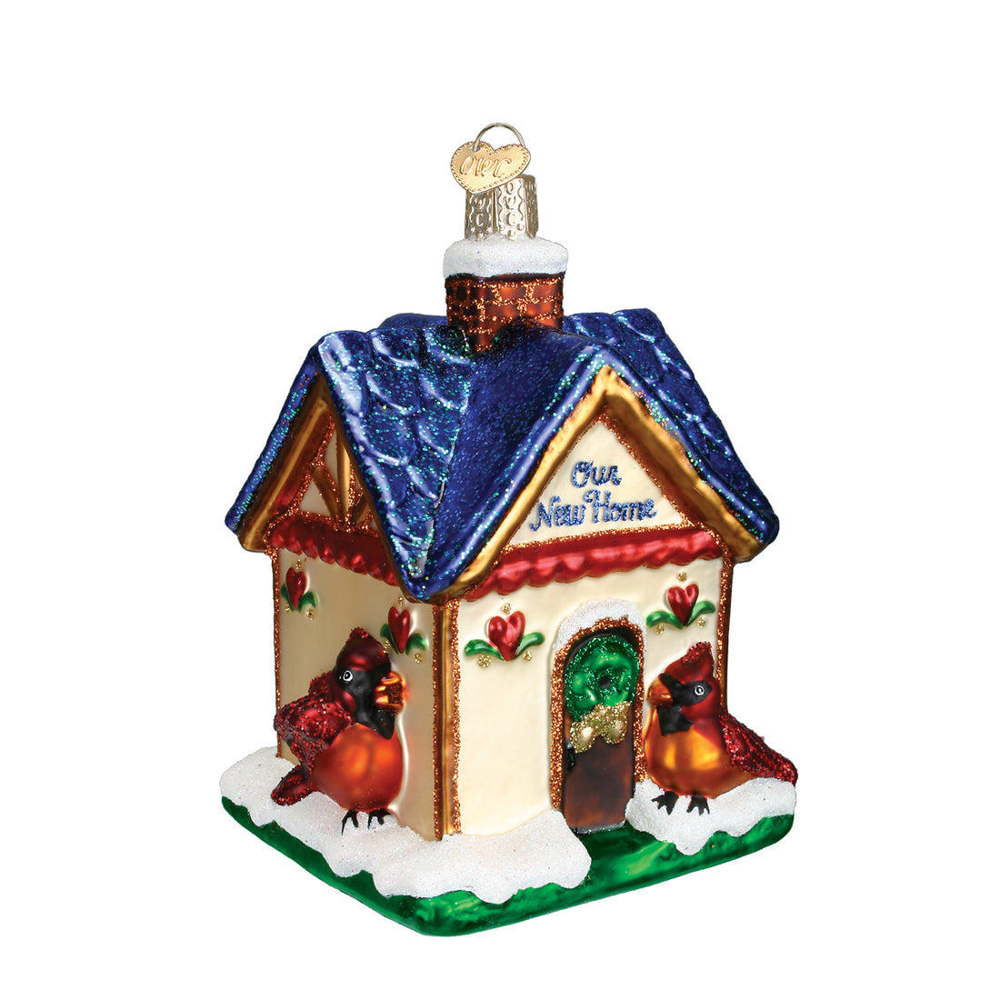 Glass house ornament with blue roof, red cardinals, and 'Our New Home' text in blue glitter.