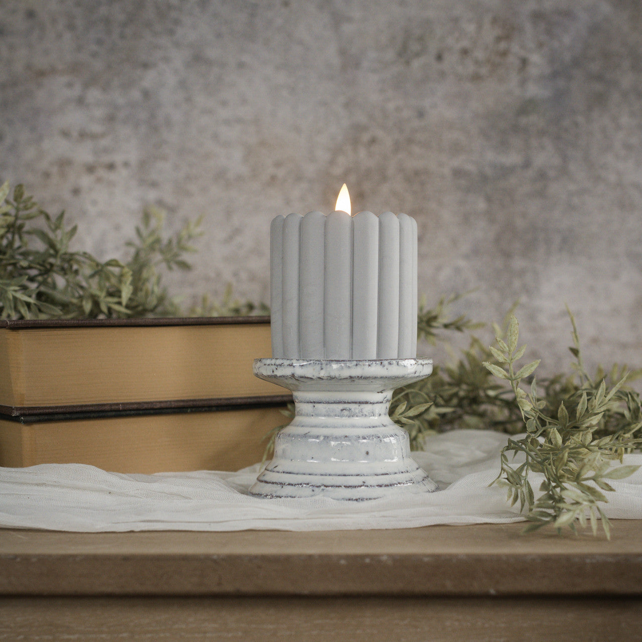 Terracotta cream pillar candle stand with a square four-inch silhouette.
