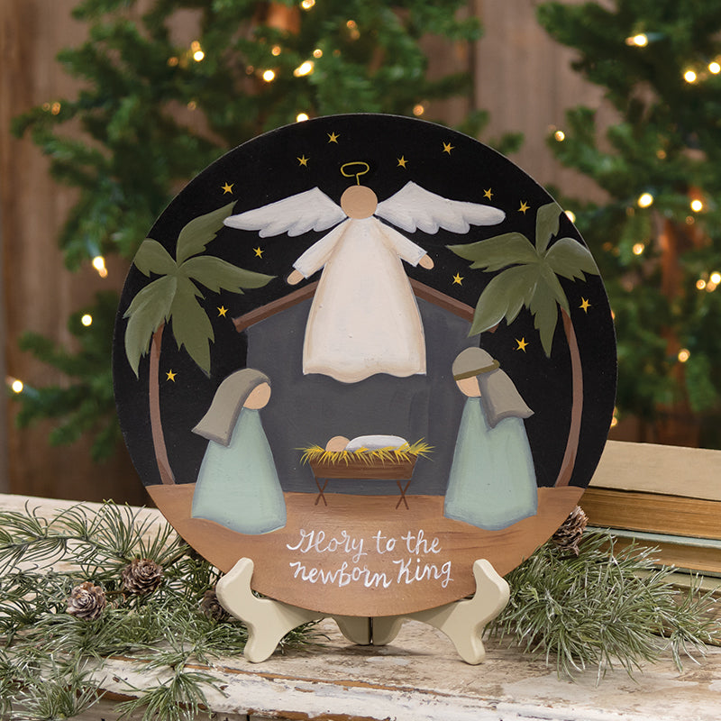 Glory to the Newborn King nativity plate featuring a gold-toned silhouette with red and blue accents against a white background.