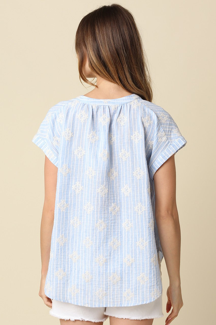 Back view of a woman wearing the Maxine Short Sleeve Print Blouse in light blue and white stripes.