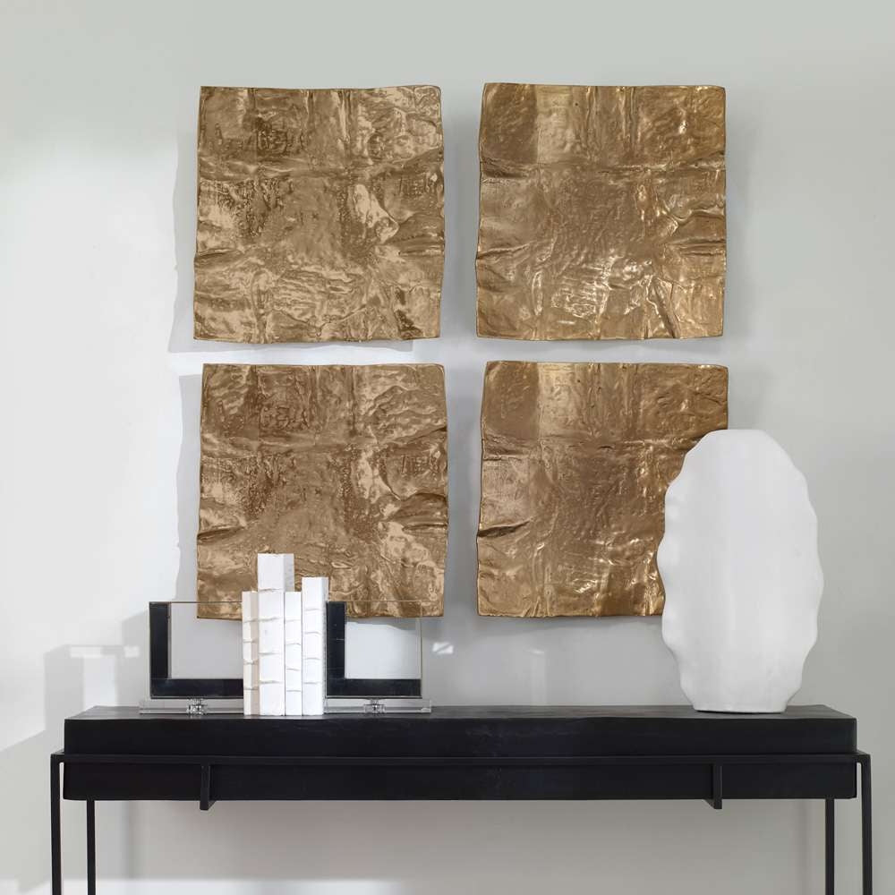 Four square, heavily textured brass-plated cast aluminum wall accents arranged in a grid.